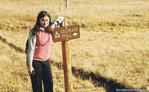 Neuroscience Ph.D. candidate Rathbun stands beside a rural mailbox in a field.