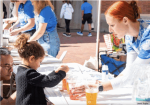 Young visitors participate in hands-on science activities at the Exploring Your Universe fair, with UCLA volunteers in blue