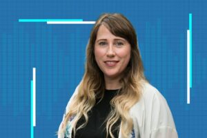 Siobhan Braybrook wearing a white sweater against a blue grid background.