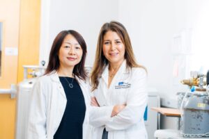 Yang and Memarzadeh in a laboratory setting with medical equipment.
